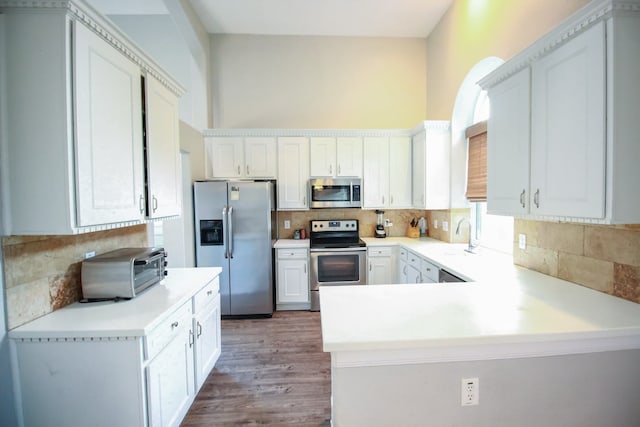 10407 Redwood Dr, Baytown, TX 77523 - kitchen with stainless steel appliances, backsplash, a sink, light countertops, and a towering ceiling