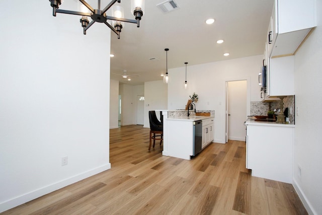 624 Pinewood Dr, Conroe, TX 77385 - kitchen featuring a kitchen breakfast bar, stainless steel dishwasher, white cabinets, light countertops, and recessed lighting
