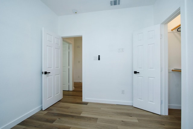 624 Pinewood Dr, Conroe, TX 77385 - unfurnished bedroom with wood finished floors, baseboards, and a spacious closet