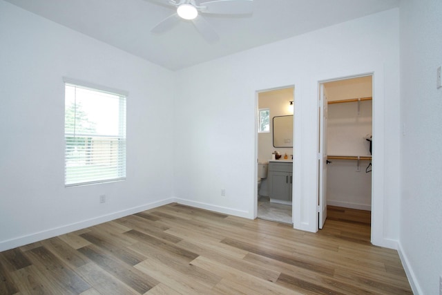 624 Pinewood Dr, Conroe, TX 77385 - unfurnished bedroom featuring a walk in closet, light wood-style floors, and a closet