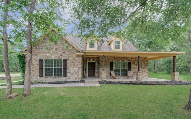 9107 Black Buck Ln, Conroe, TX 77303 - view of front of home featuring a front yard, brick siding, and covered porch