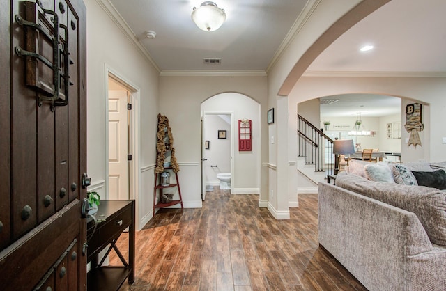 9107 Black Buck Ln, Conroe, TX 77303 - foyer with ornamental molding, dark wood-style flooring, stairway, baseboards, and arched walkways