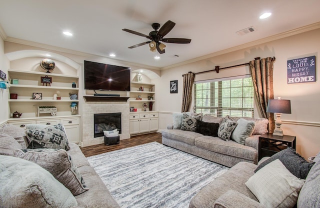 9107 Black Buck Ln, Conroe, TX 77303 - living room with wood finished floors, ceiling fan, crown molding, a glass covered fireplace, and recessed lighting
