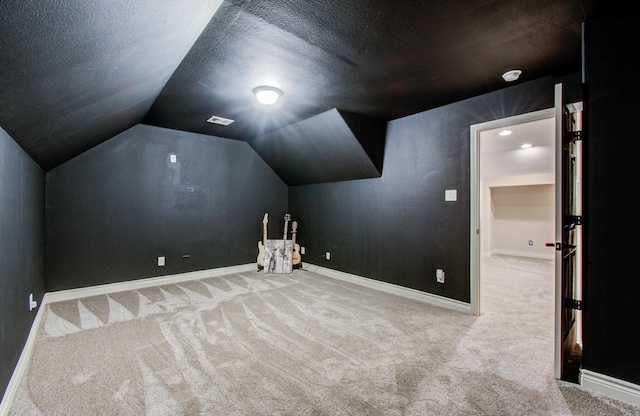 9107 Black Buck Ln, Conroe, TX 77303 - additional living space with carpet floors, lofted ceiling, baseboards, and a textured ceiling
