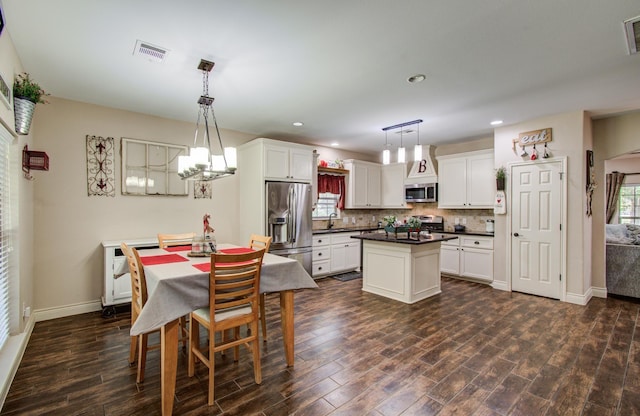 9107 Black Buck Ln, Conroe, TX 77303 - kitchen with stainless steel appliances, a center island, dark countertops, dark wood-style flooring, and a sink
