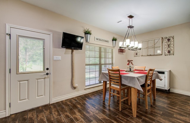 9107 Black Buck Ln, Conroe, TX 77303 - dining room featuring healthy amount of natural light, dark wood-type flooring, baseboards, and a chandelier