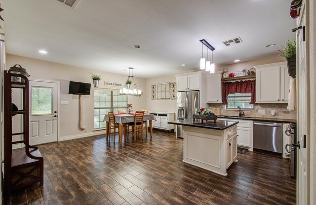 9107 Black Buck Ln, Conroe, TX 77303 - kitchen with appliances with stainless steel finishes, a sink, dark countertops, white cabinets, and dark wood-type flooring