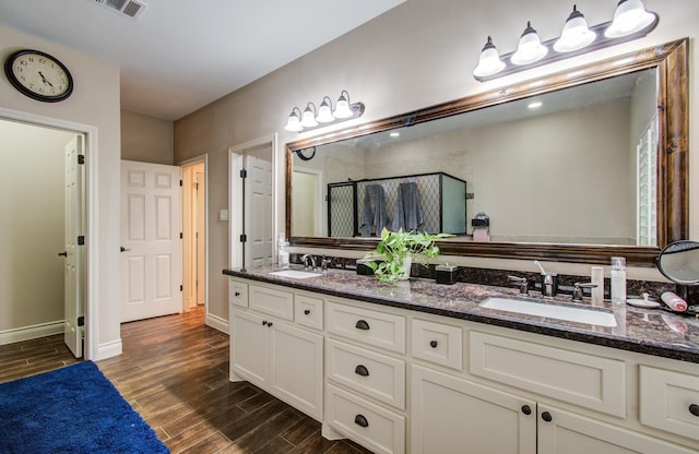 9107 Black Buck Ln, Conroe, TX 77303 - full bath featuring double vanity, a shower stall, wood finished floors, and baseboards