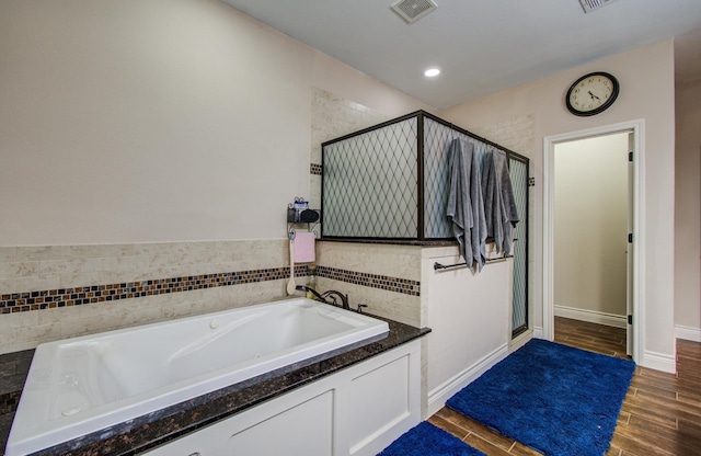 9107 Black Buck Ln, Conroe, TX 77303 - full bath with a shower stall, a bath, wood finished floors, and recessed lighting