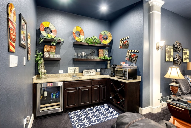 2803 Chester Knoll Ct, Katy, TX 77494 - indoor dry bar featuring wine cooler, stainless steel microwave, baseboards, a textured wall, and dark colored carpet
