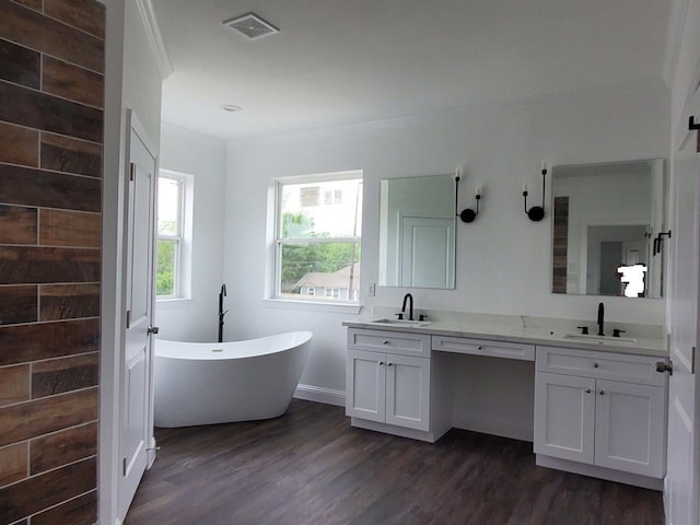 2615 Campbell St, Houston, TX 77026 - bathroom featuring double vanity, a soaking tub, wood finished floors, and baseboards