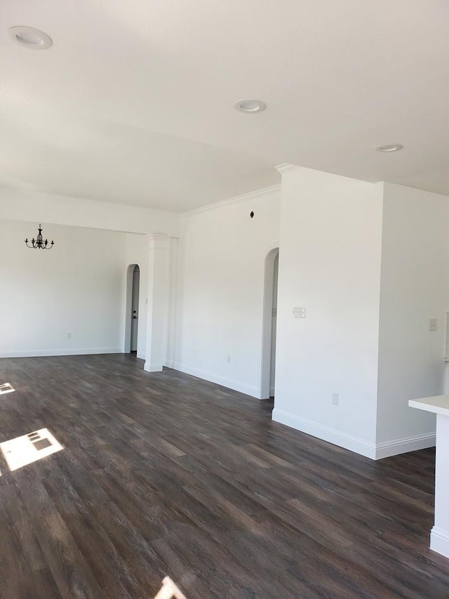 2615 Campbell St, Houston, TX 77026 - empty room featuring arched walkways, dark wood-type flooring, baseboards, and recessed lighting