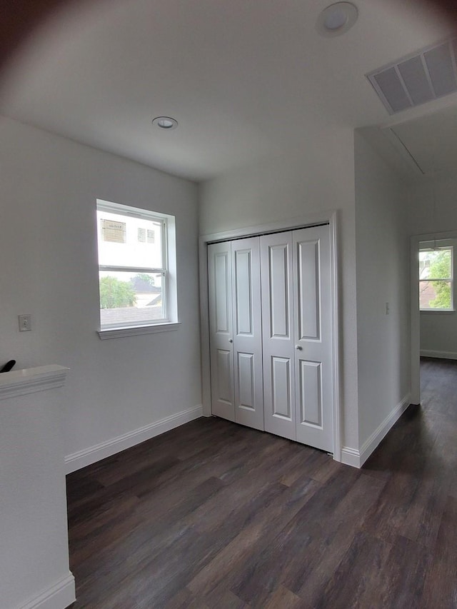 2615 Campbell St, Houston, TX 77026 - unfurnished bedroom featuring attic access, dark wood-style floors, baseboards, and a closet
