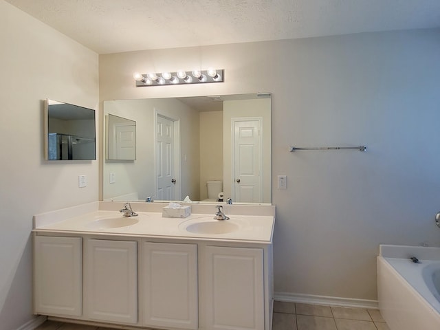 6135 Shelbourne Park Ln, Houston, TX 77084 - bathroom featuring double vanity, a bath, tile patterned floors, toilet, and baseboards