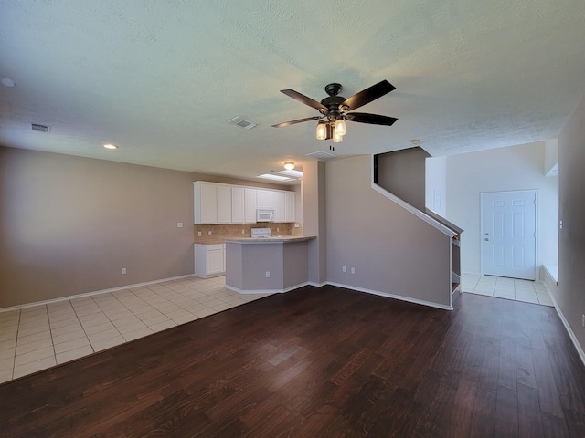 6135 Shelbourne Park Ln, Houston, TX 77084 - unfurnished living room with light wood-style flooring, ceiling fan, baseboards, a textured ceiling, and recessed lighting
