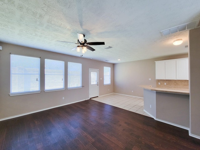 6135 Shelbourne Park Ln, Houston, TX 77084 - unfurnished living room featuring wood finished floors, a ceiling fan, baseboards, and a textured ceiling