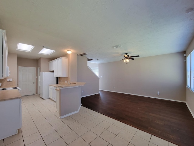 6135 Shelbourne Park Ln, Houston, TX 77084 - kitchen featuring white appliances, light tile patterned floors, white cabinets, ceiling fan, and light countertops