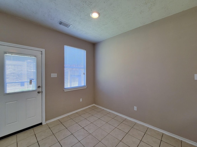 6135 Shelbourne Park Ln, Houston, TX 77084 - doorway to outside featuring a textured ceiling, baseboards, and light tile patterned floors