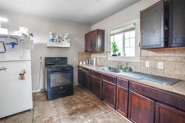 3603 Providence St, Houston, TX 77020 - kitchen with black gas range, freestanding refrigerator, a sink, decorative backsplash, and light tile patterned flooring
