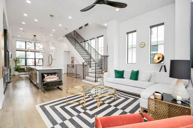 2917 Dallas St, Houston, TX 77003 - living room featuring stairway, recessed lighting, light wood finished floors, ceiling fan, and a chandelier