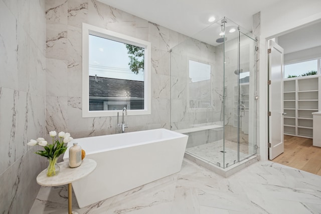 1203 Bomar St, Houston, TX 77006 - bathroom with a marble finish shower, a freestanding bath, tile walls, and a spacious closet