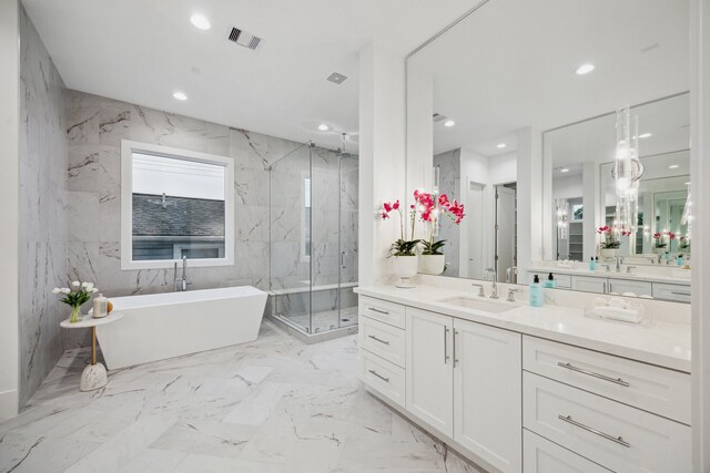 1203 Bomar St, Houston, TX 77006 - bathroom featuring a freestanding bath, a marble finish shower, vanity, recessed lighting, and marble tiled flooring