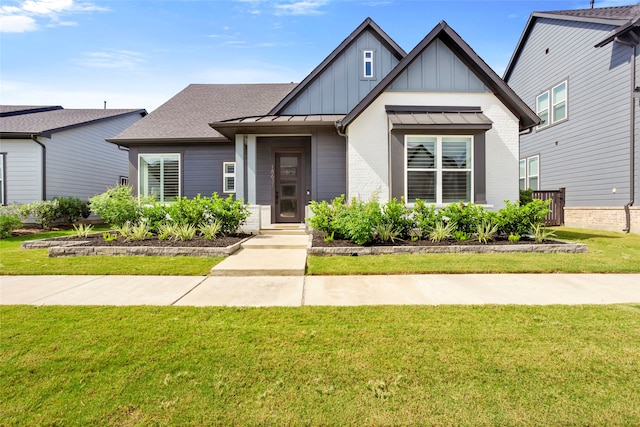 18631 Joyous Ln, Cypress, TX 77433 - view of front of property with a front yard, board and batten siding, a standing seam roof, roof with shingles, and metal roof