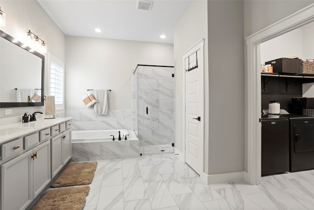 18631 Joyous Ln, Cypress, TX 77433 - bathroom with separate washer and dryer, a bath, a stall shower, marble look tiles, and recessed lighting