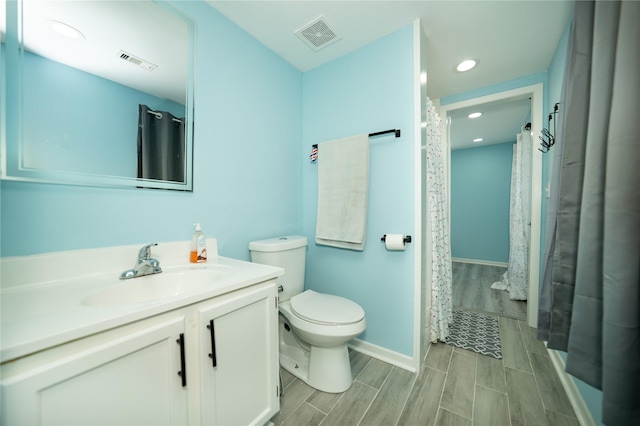 570 Fm 232, Crockett, TX 75835 - bathroom with vanity, toilet, wood tiled floors, recessed lighting, and baseboards