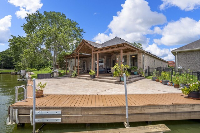 13685 Lakeside Place Dr, Willis, TX 77318 - back of property featuring a water view, brick siding, and a patio