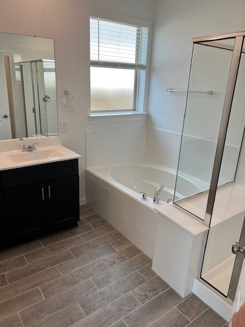26715 Grandiflora Dr, Magnolia, TX 77355 - bathroom with a bath, vanity, a shower stall, and wood finished floors