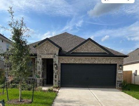 26715 Grandiflora Dr, Magnolia, TX 77355 - view of front of property with driveway, a garage, and stone siding