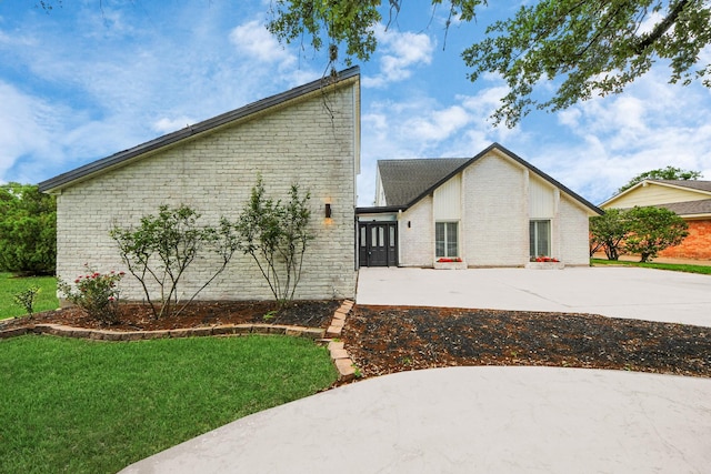 722 Merrick Dr, Sugar Land, TX 77478 - view of property exterior featuring brick siding, a lawn, driveway, and a patio