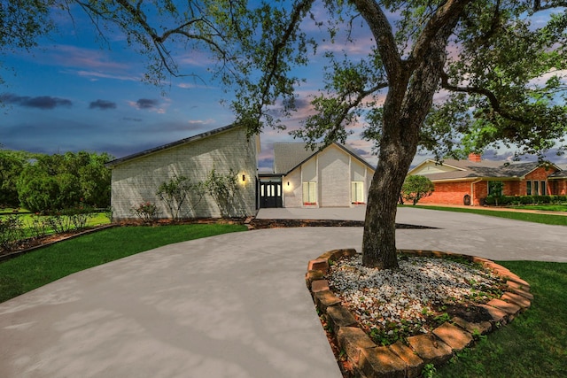 722 Merrick Dr, Sugar Land, TX 77478 - mid-century inspired home with curved driveway, brick siding, and a yard
