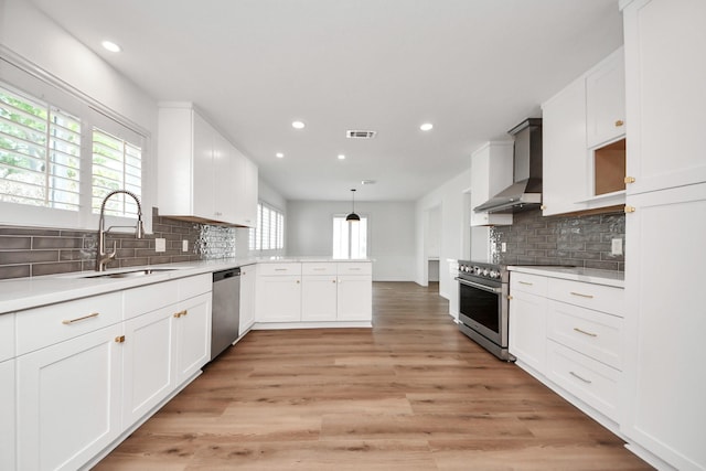 722 Merrick Dr, Sugar Land, TX 77478 - kitchen featuring wall chimney range hood, a sink, appliances with stainless steel finishes, recessed lighting, and backsplash