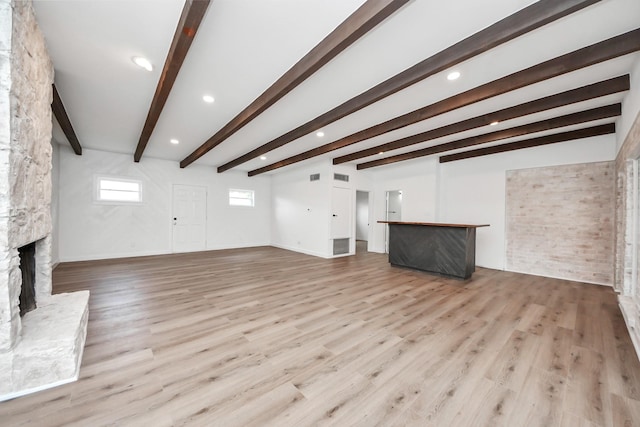 722 Merrick Dr, Sugar Land, TX 77478 - unfurnished living room with a stone fireplace, beam ceiling, light wood-type flooring, recessed lighting, and baseboards
