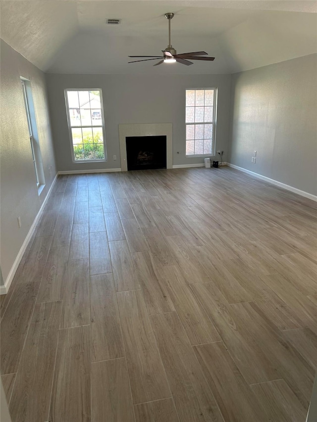 12702 River Bend Dr, Mont Belvieu, TX 77523 - unfurnished living room featuring lofted ceiling, wood finished floors, a ceiling fan, healthy amount of natural light, and baseboards