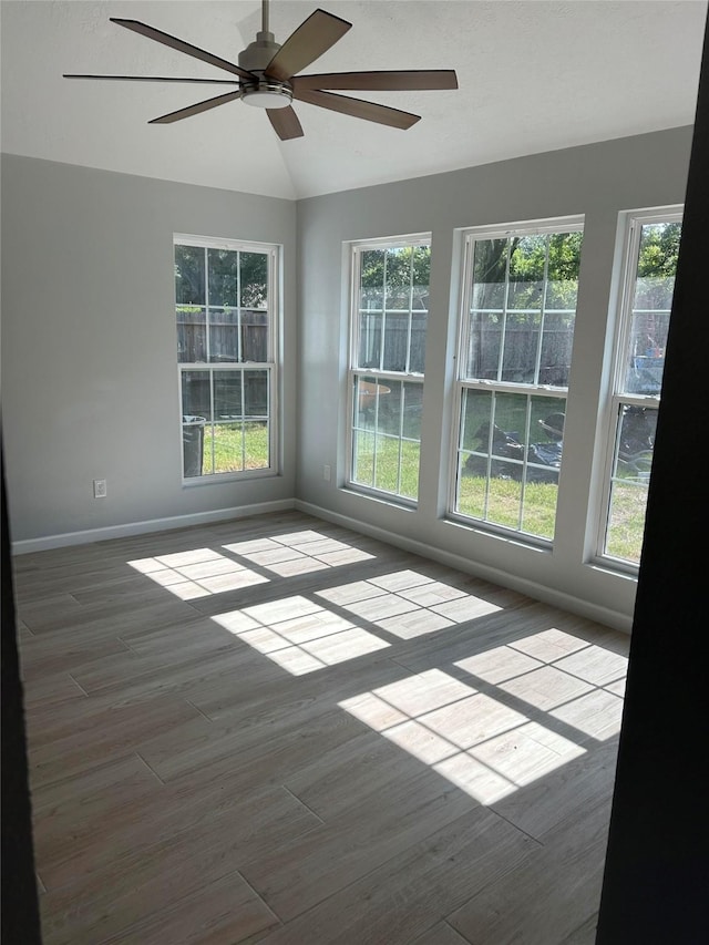12702 River Bend Dr, Mont Belvieu, TX 77523 - empty room with ceiling fan, plenty of natural light, baseboards, vaulted ceiling, and wood finished floors