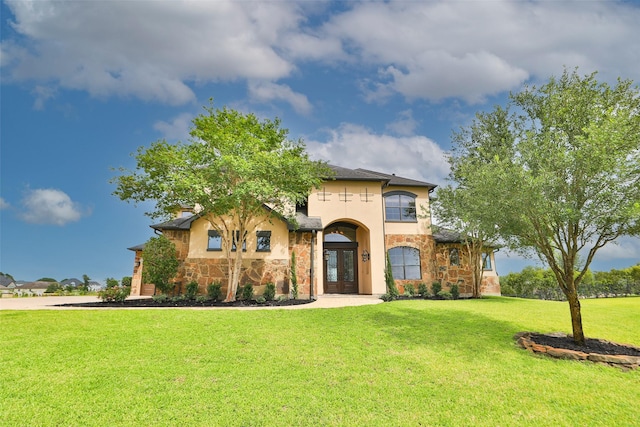 8410 Den Oak Dr, Richmond, TX 77406 - view of front of house with french doors, stone siding, a front yard, and stucco siding