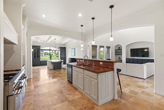 8410 Den Oak Dr, Richmond, TX 77406 - kitchen with a kitchen island with sink, appliances with stainless steel finishes, a breakfast bar area, arched walkways, and dark countertops
