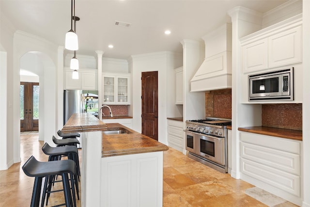8410 Den Oak Dr, Richmond, TX 77406 - kitchen with stainless steel appliances, decorative backsplash, arched walkways, a kitchen bar, and recessed lighting