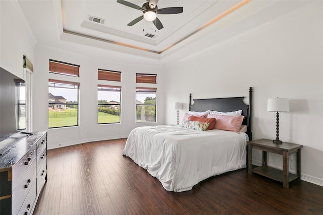 8410 Den Oak Dr, Richmond, TX 77406 - bedroom with a tray ceiling, dark wood-style flooring, ornamental molding, and a ceiling fan