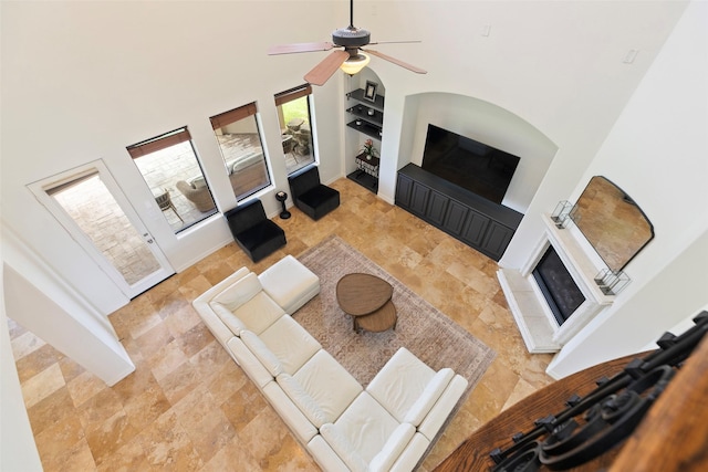 8410 Den Oak Dr, Richmond, TX 77406 - living area with a towering ceiling, ceiling fan, built in features, and stone finish flooring