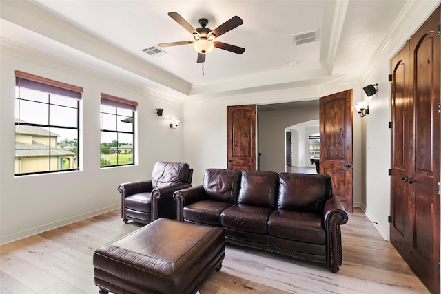 8410 Den Oak Dr, Richmond, TX 77406 - home theater room with arched walkways, a ceiling fan, a raised ceiling, light wood-style floors, and ornamental molding
