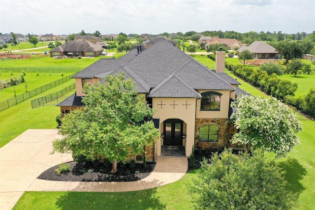 8410 Den Oak Dr, Richmond, TX 77406 - french country inspired facade with french doors, stone siding, stucco siding, a chimney, and roof with shingles