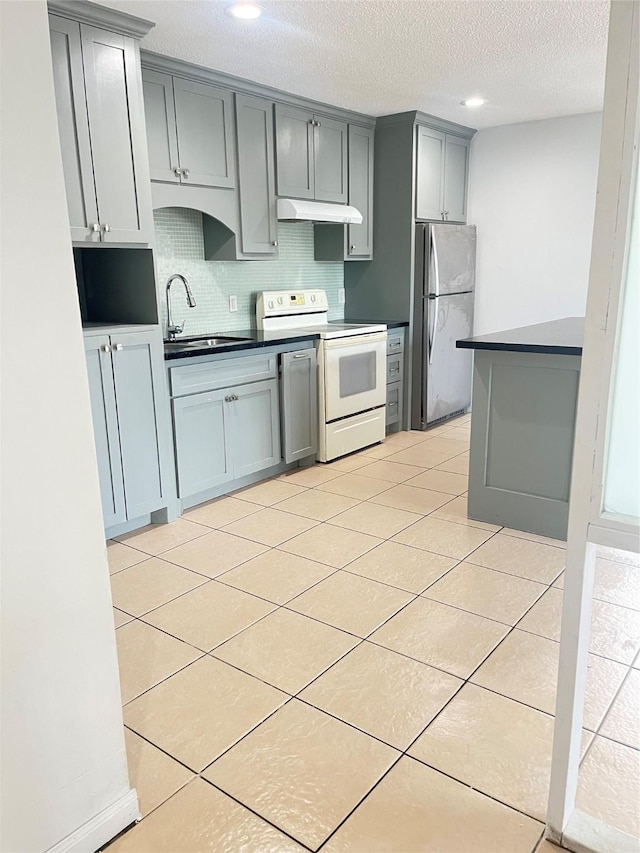 5526 Stonewall St, Houston, TX 77020 - kitchen with freestanding refrigerator, electric stove, under cabinet range hood, gray cabinetry, and a sink