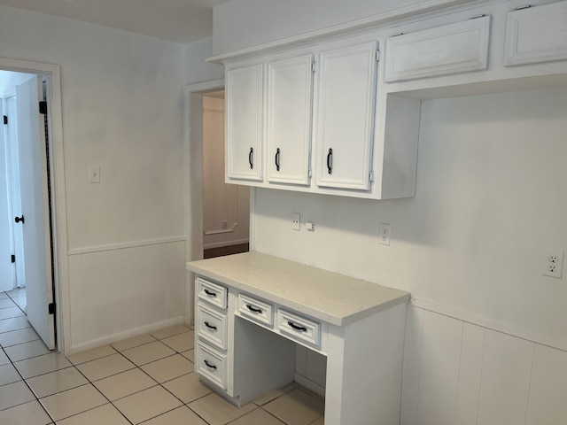3714 Woodbriar Dr, Houston, TX 77068 - kitchen with a wainscoted wall, white cabinets, light tile patterned flooring, and light stone countertops