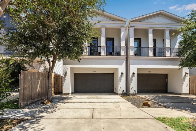 1026 Adele St, Houston, TX 77009 - neoclassical / greek revival house with a garage, driveway, and stucco siding