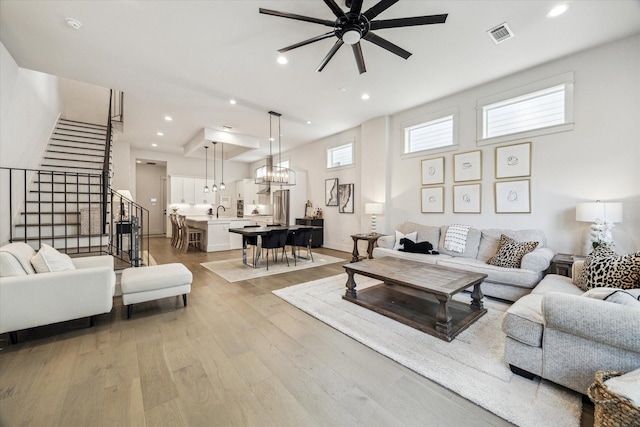 1026 Adele St, Houston, TX 77009 - living area with a ceiling fan, light wood finished floors, stairway, recessed lighting, and a chandelier