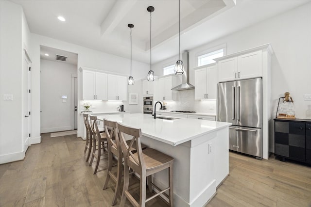 1026 Adele St, Houston, TX 77009 - kitchen with high end refrigerator, wall chimney range hood, a sink, light wood finished floors, and backsplash